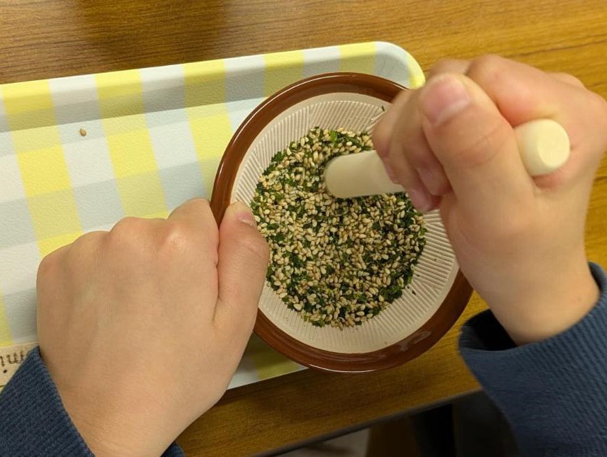 すり鉢と棒をつかってふりかけをつくっている様子