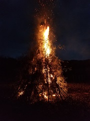 竹を組み合わせて作ったやぐらが赤々と燃えているどんど焼きの写真