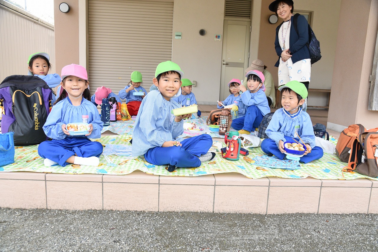 園児たちが、みんなでお弁当を食べている様子