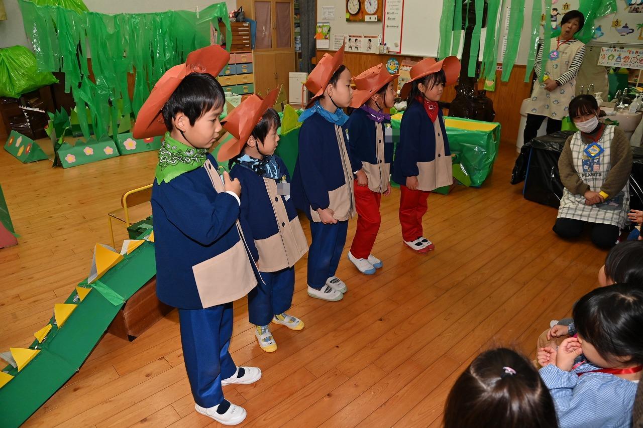 年長児5名が横並びで立って、その前に年少・年中児が座っており、向かい合っている様子