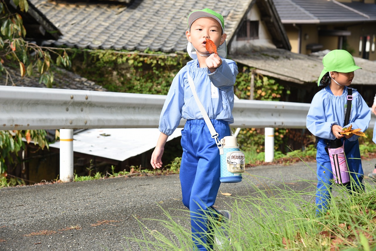 男児が落ち葉を見つけて見せている様子