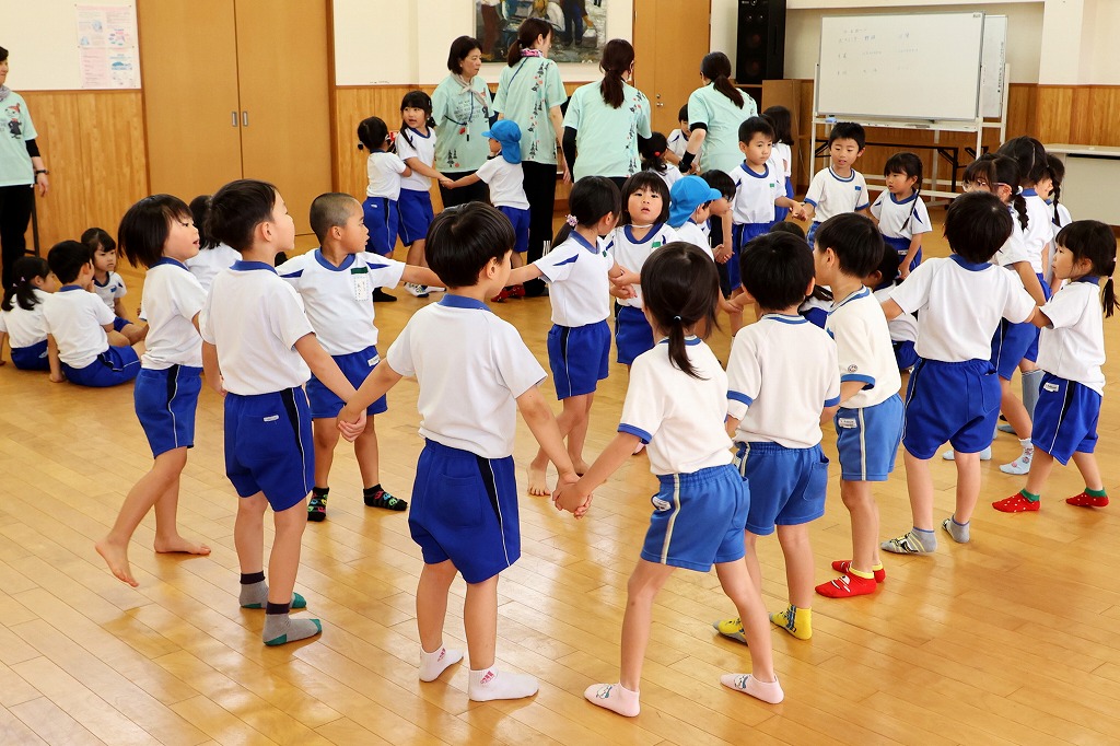 園児たちが手をつないで丸くなっている様子