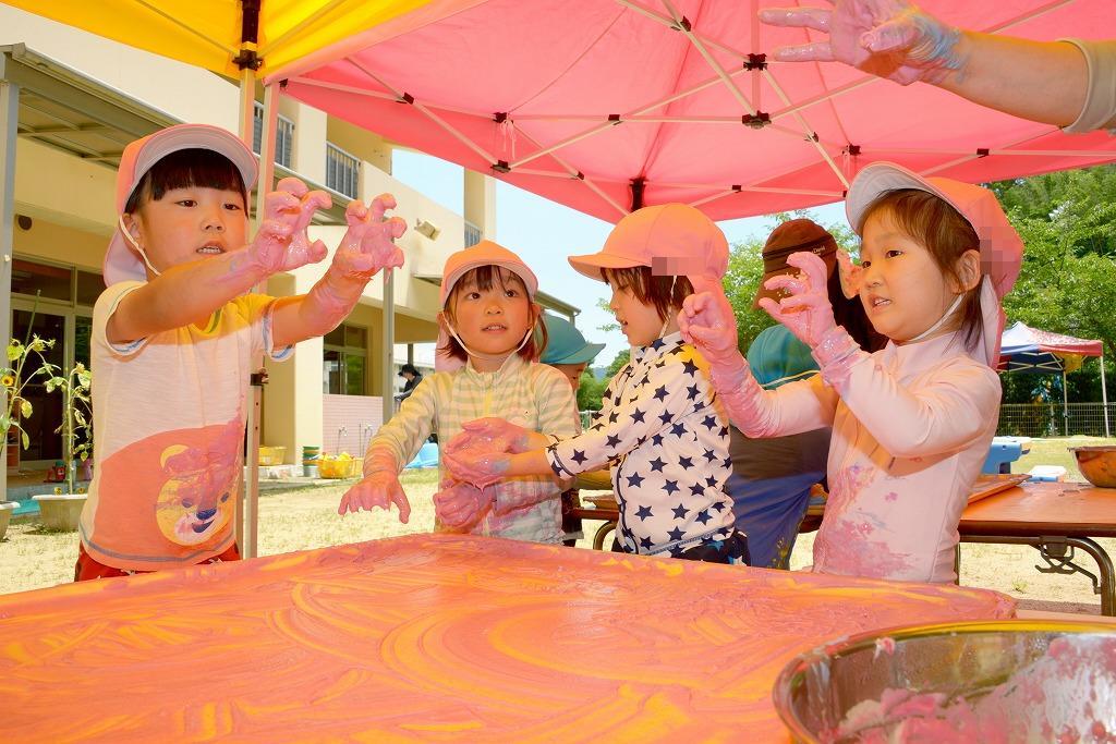 園児4人が両手につけた小麦粉粘土を「ほらー」っとお化けのように見せてぽーずをとっている様子