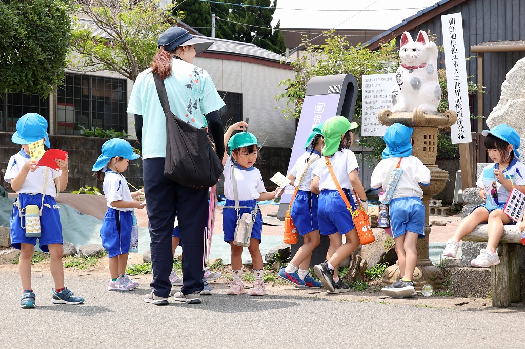 園児たちが探検カードにのっている招き猫を見つけて喜んでいる様子