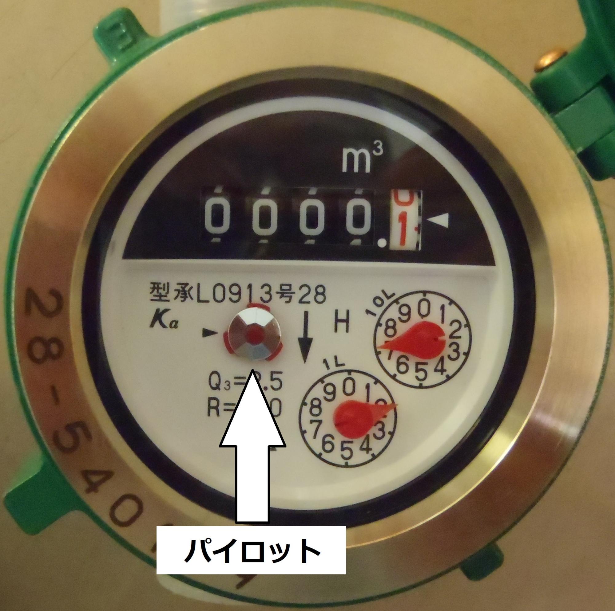 水道メーターに白い矢印で銀色のパイロットを示している写真