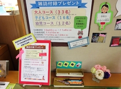 雑誌付録プレゼントのポスターが壁に貼られ、応募券が置かれている写真