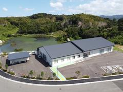 後方に山があり、左側に小さい建物、2棟続きの白い外壁の建物が並んでいるふれあい交流館の外観写真