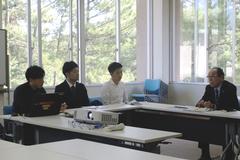 コの字型のテーブルに着席している男性3名と、町長の写真