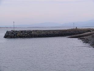 岸から細く突き出した、石造りの先波止の写真
