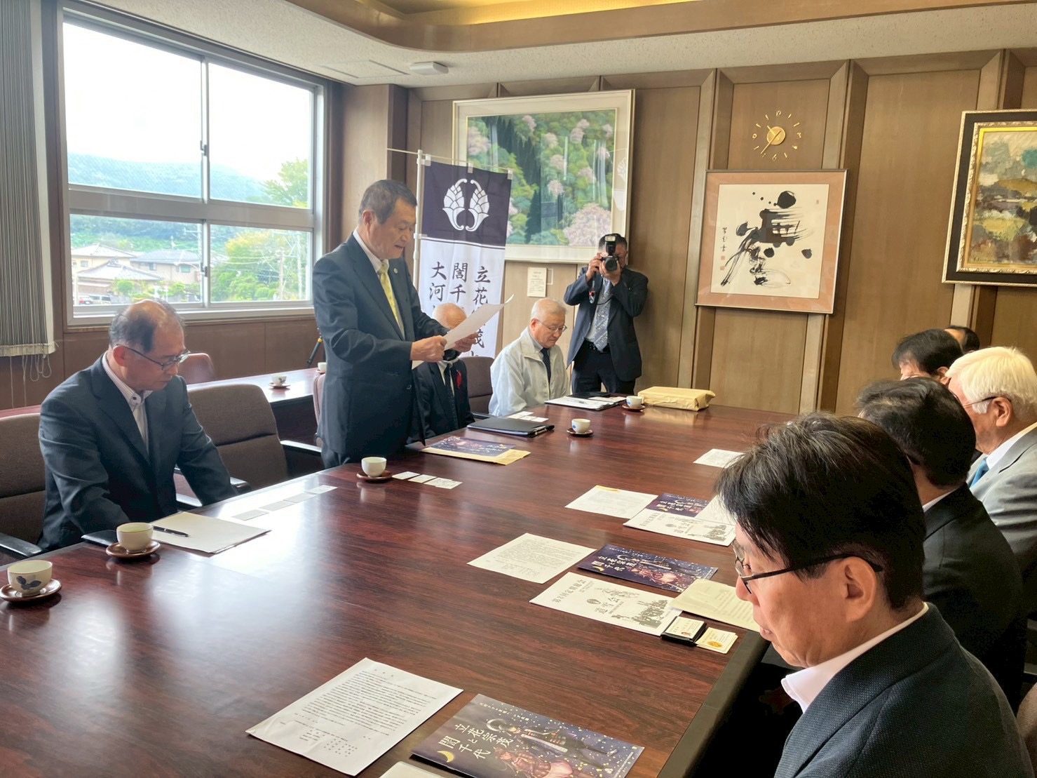 杉尾会長があいさつ文を読んでいます。