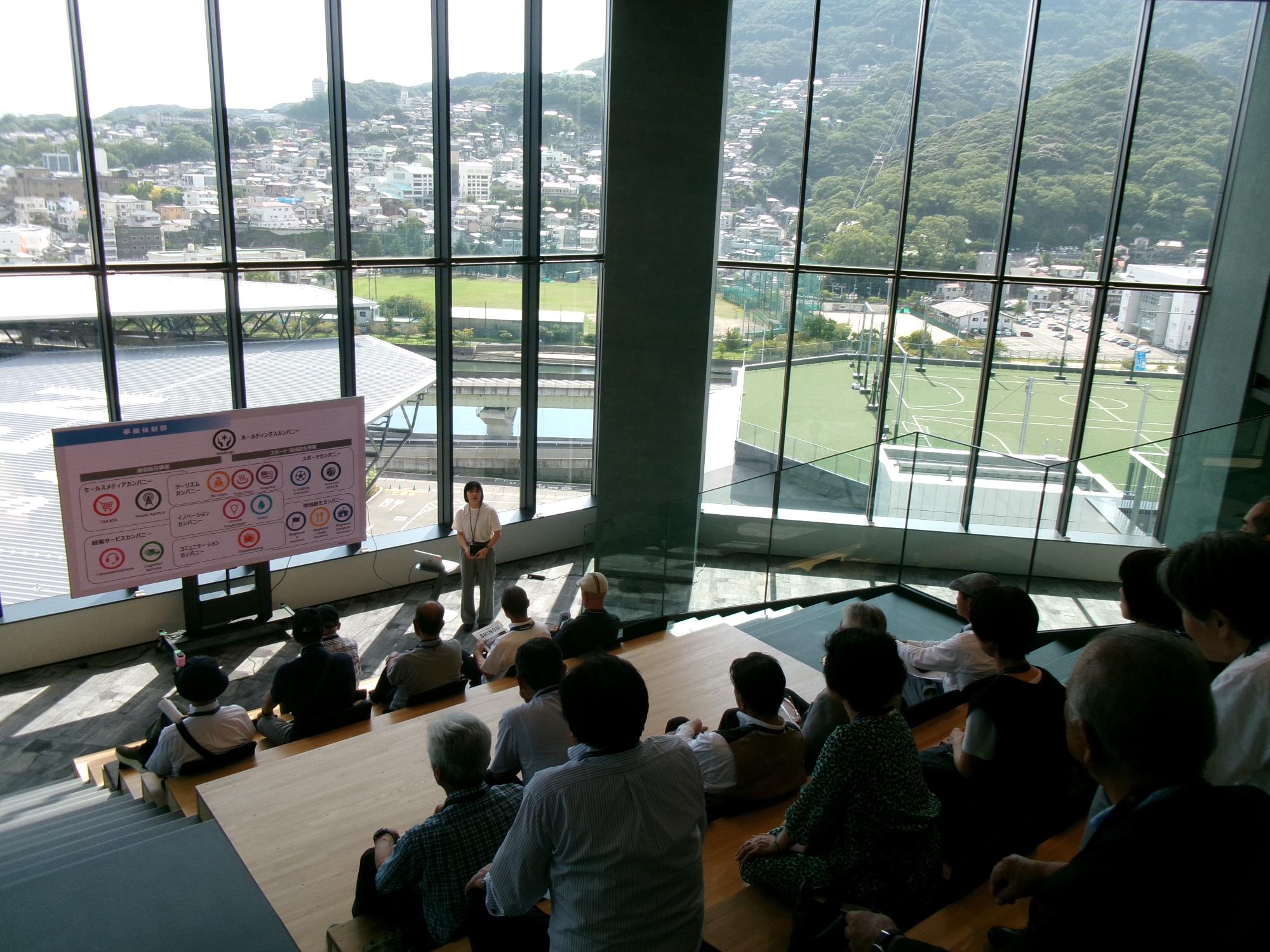 長崎スタジアムシティのコワーキングスペースで企画の説明をきく様子