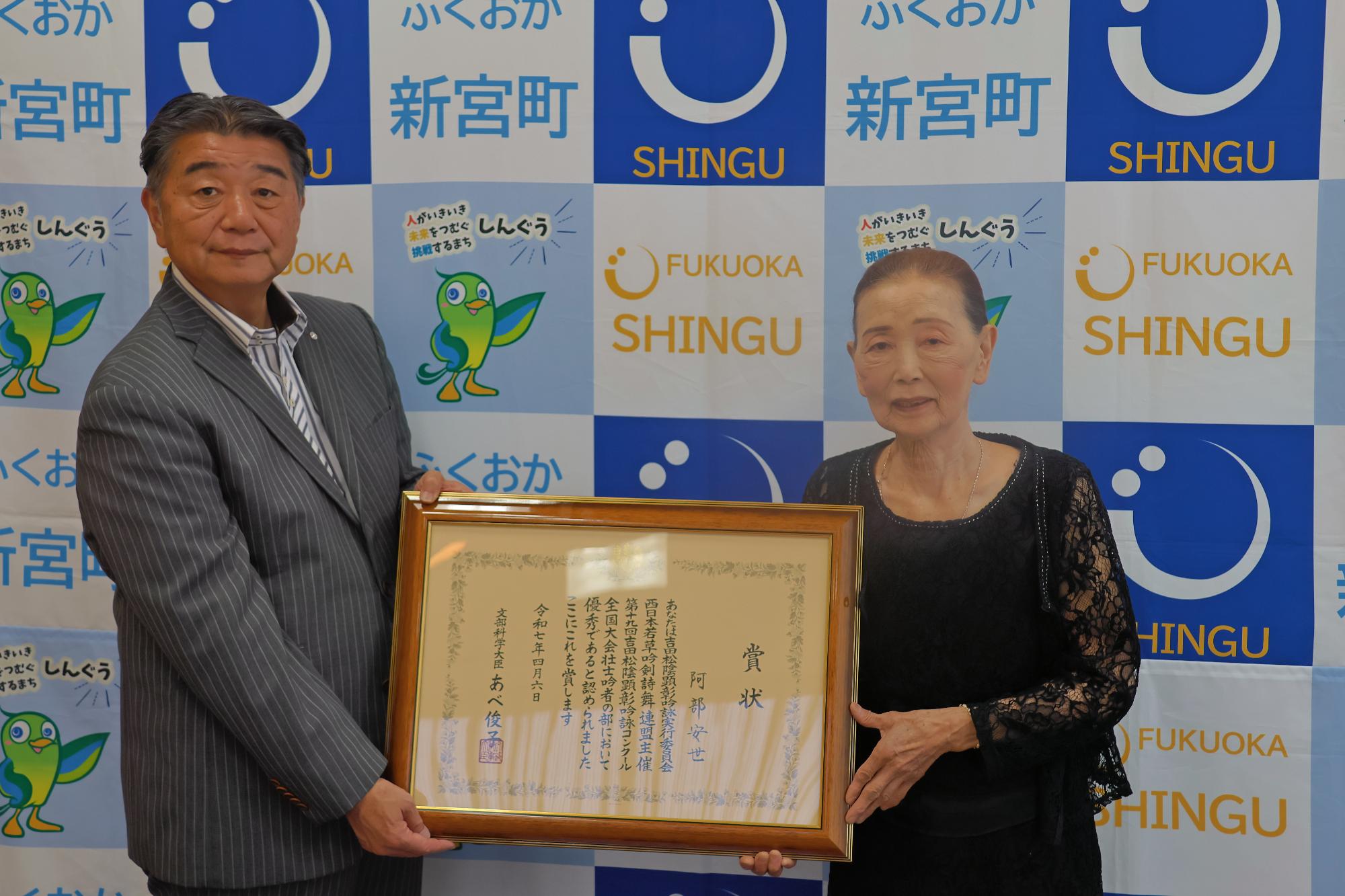 賞状を手に記念撮影をする桐島町長（左）と阿部さん（右）