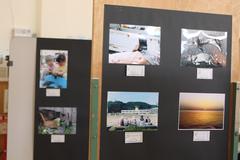 展示スペースの黒い壁に写真が貼ってある、フォトコンテストの様子の写真