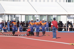 競技開始前、4人の選手が右手をあげて頭の横に手をかざし敬礼をしている写真