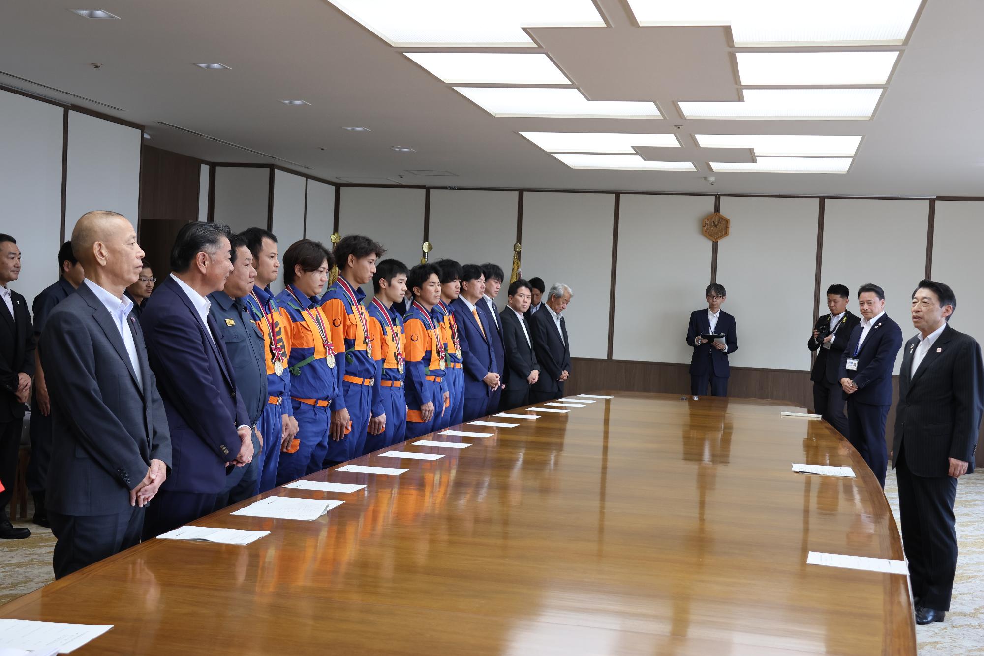 服部知事と町長、議長、新宮町消防団員が挨拶をする様子の写真