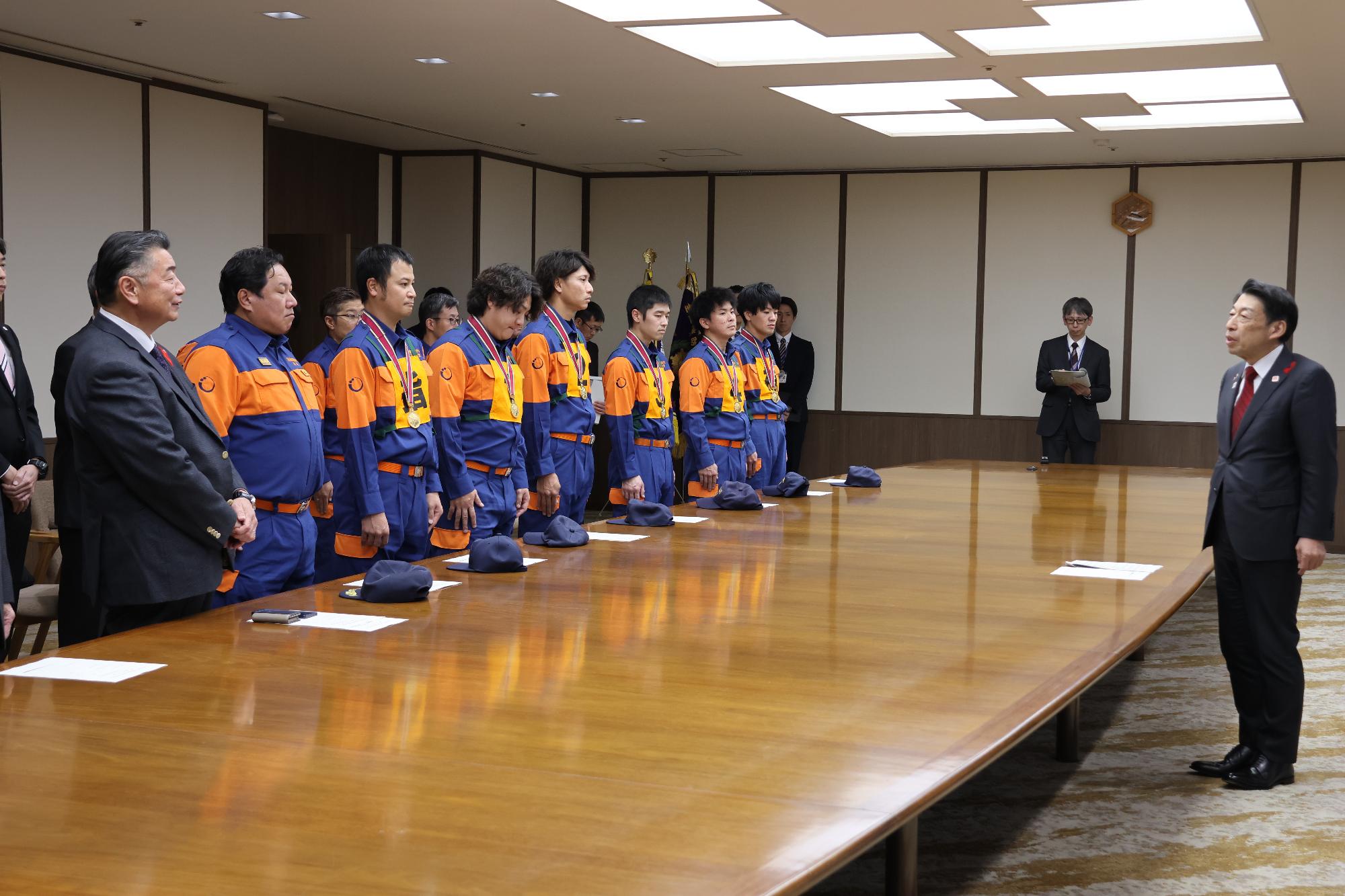 服部知事と町長、議長、新宮町消防団員が挨拶をする様子の写真