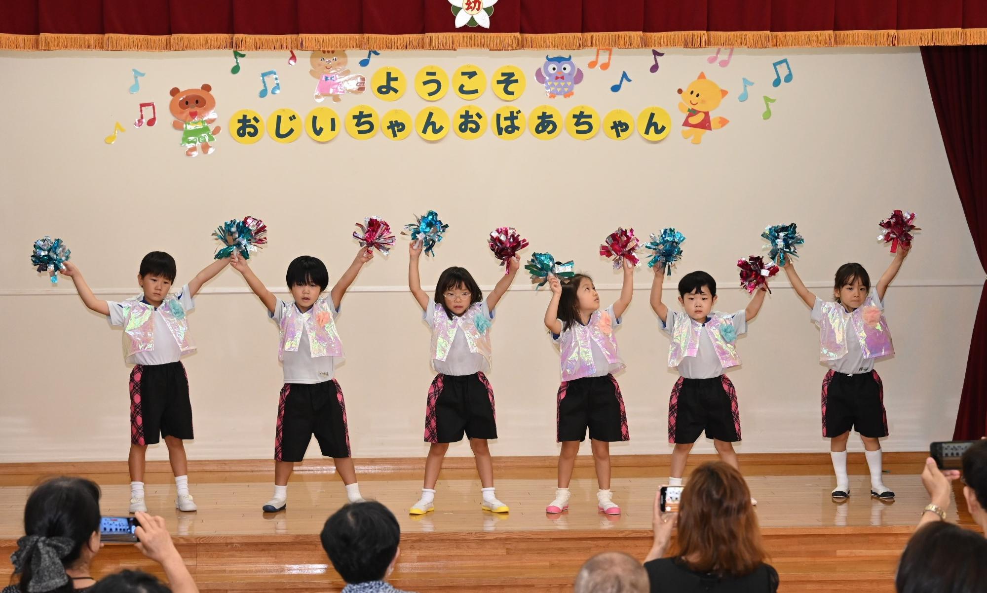 年長さんがキラキラポンポンを持って踊っているところ