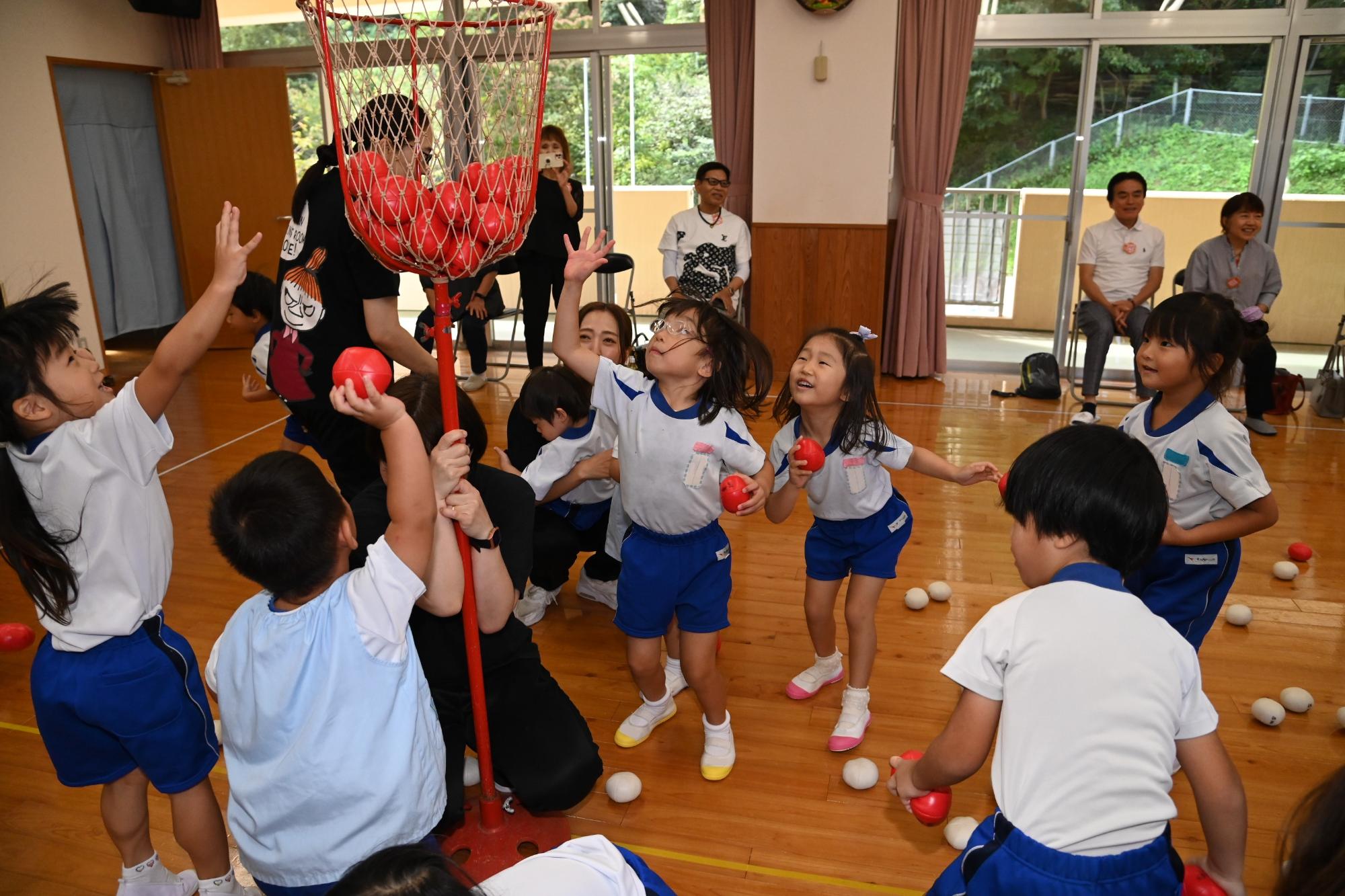 赤チームの子ども達が玉入れをしているところ