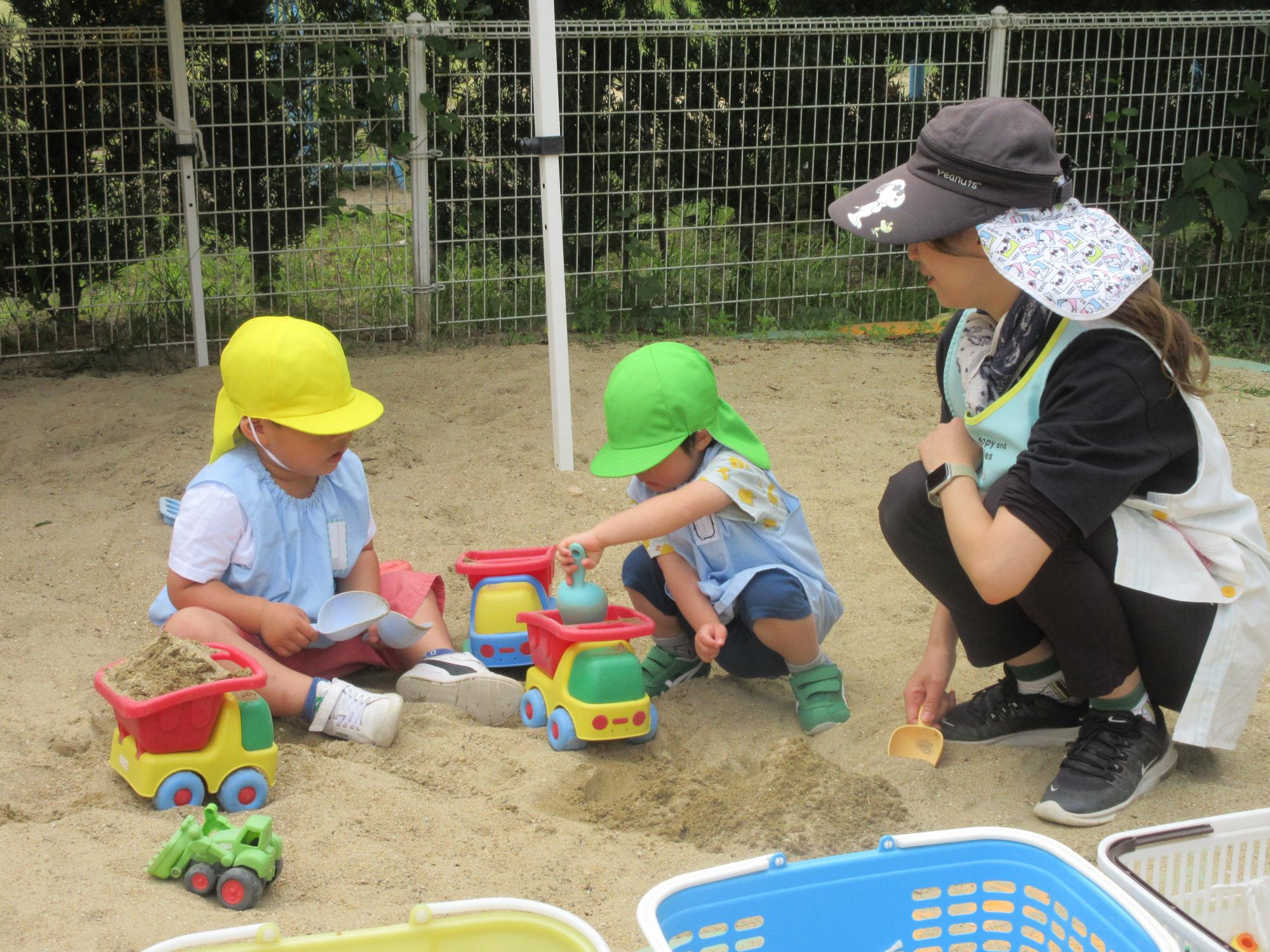 砂場で遊ぶ年少児