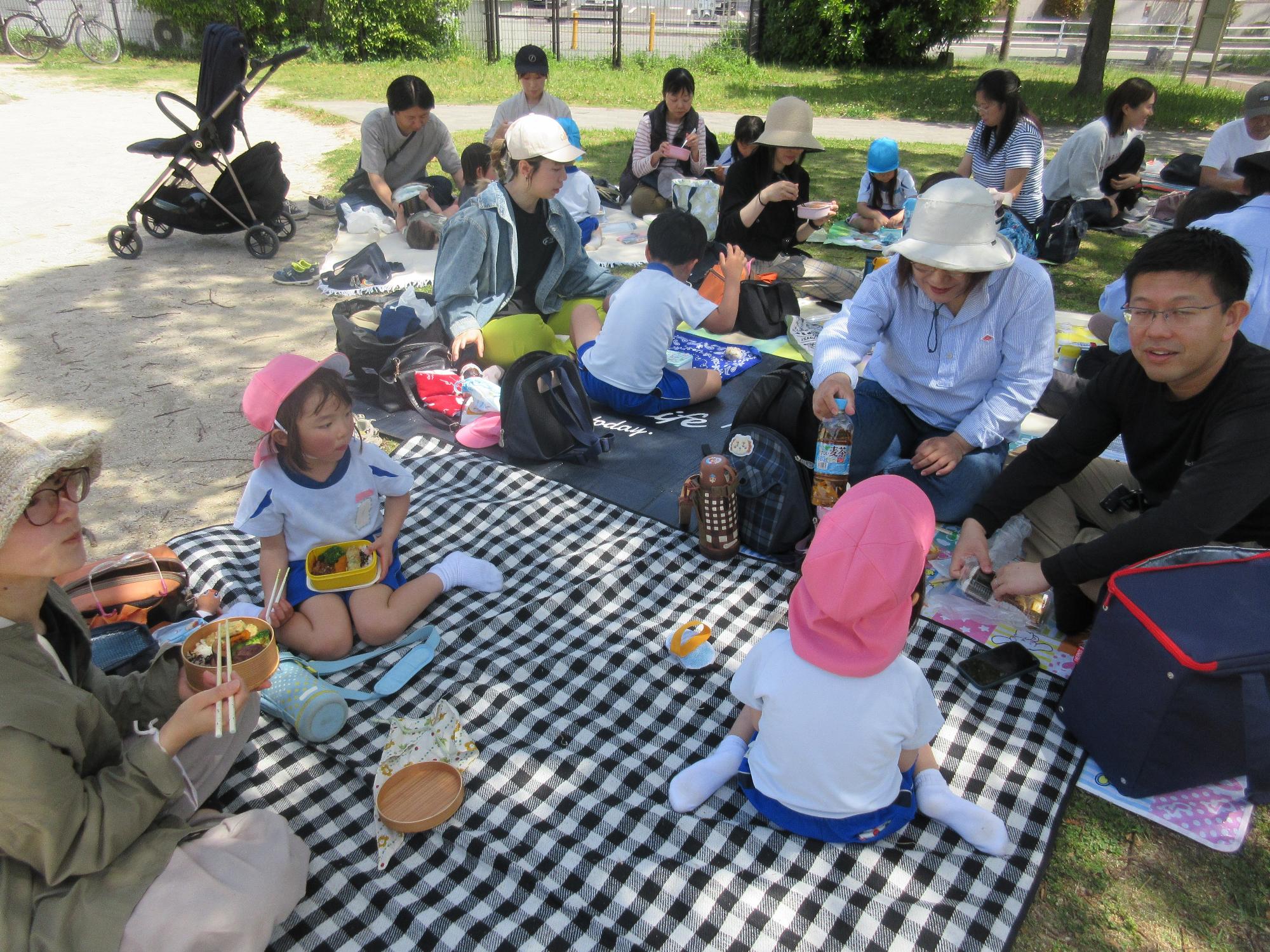 シートに座ってみんなで一緒にお弁当を食べているところ
