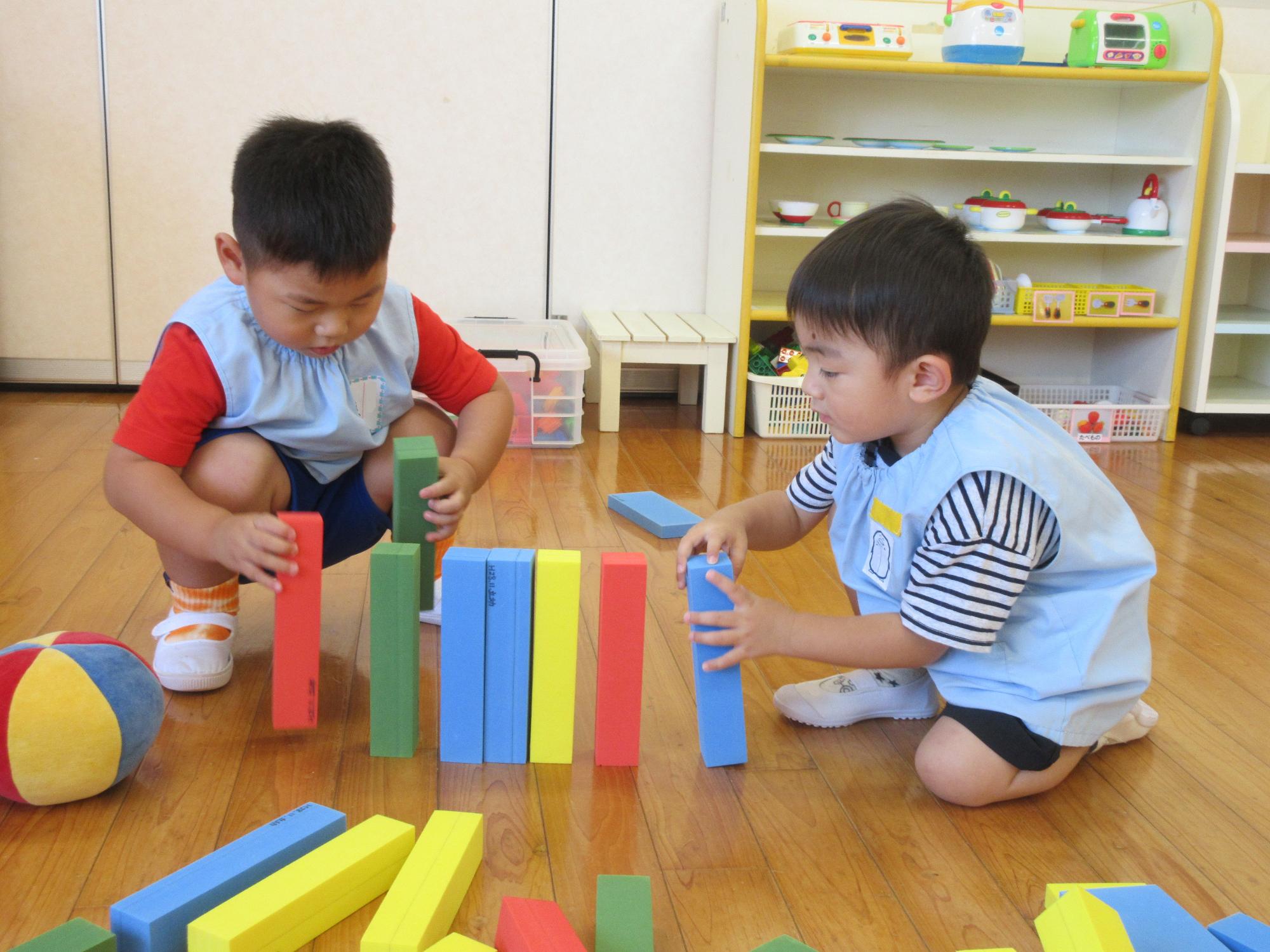 積み木を並べて遊ぶ満3歳児