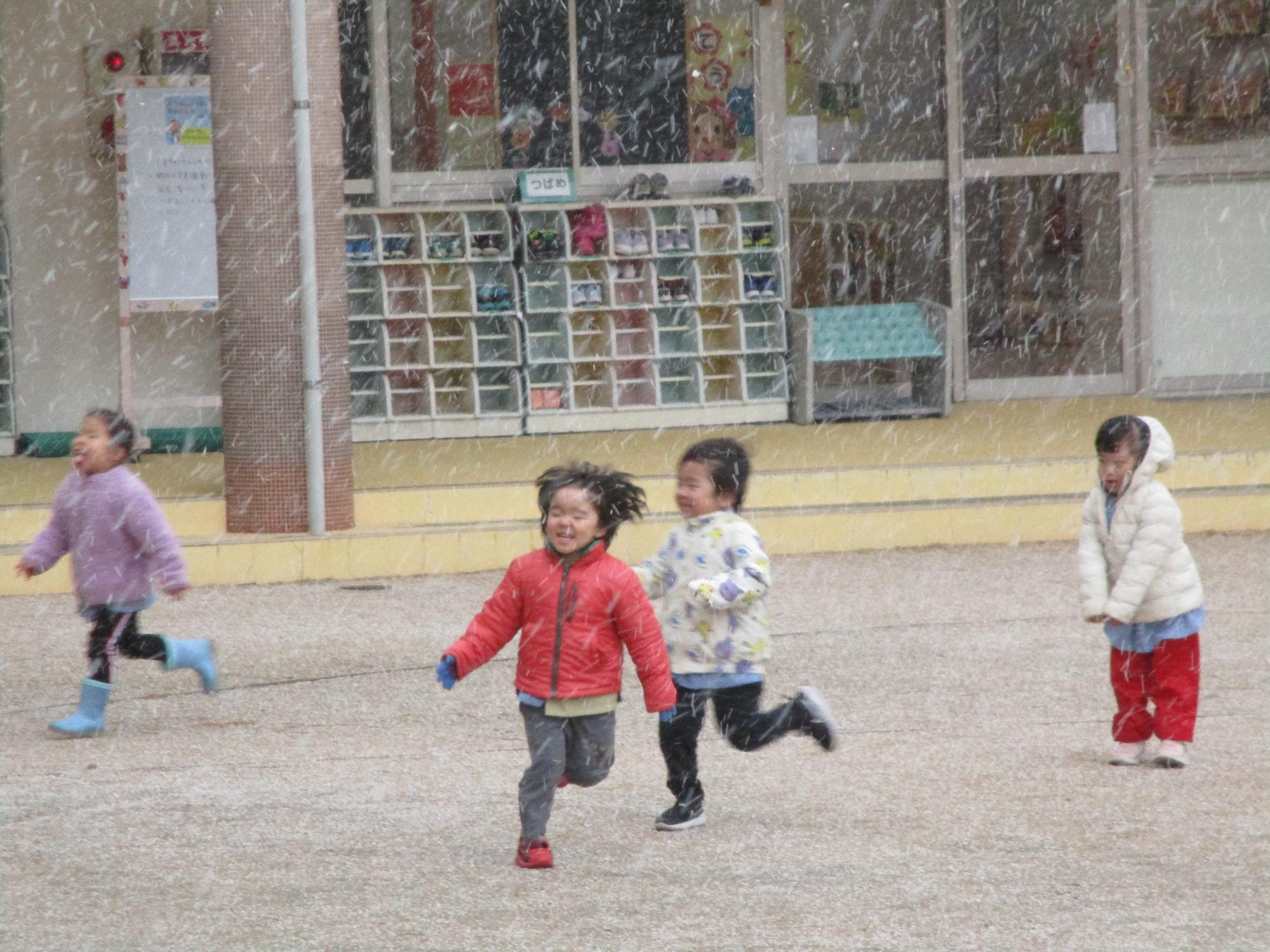 雪と一緒に走る子ども達