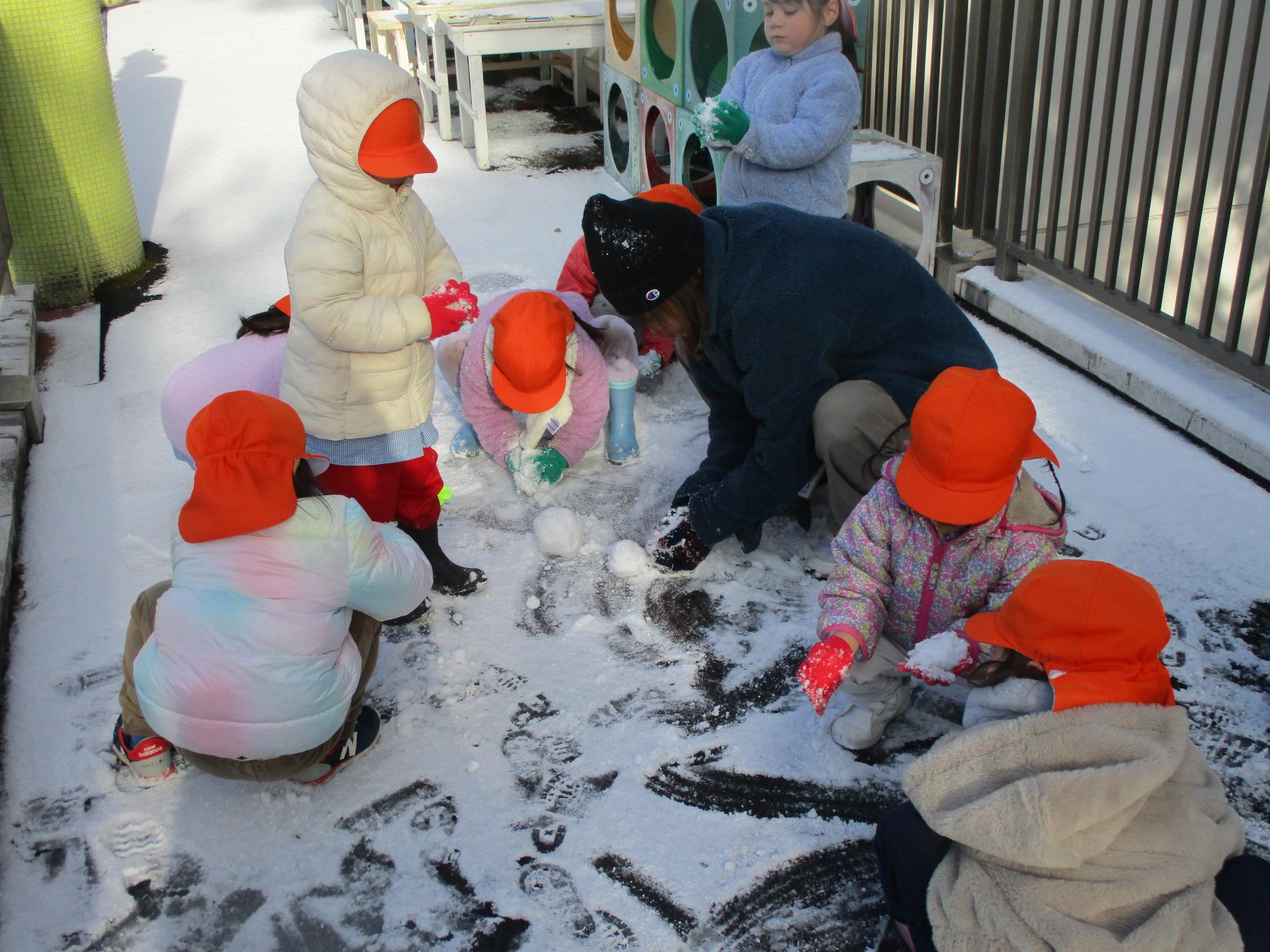 テラスに積もった雪を集める年少さん