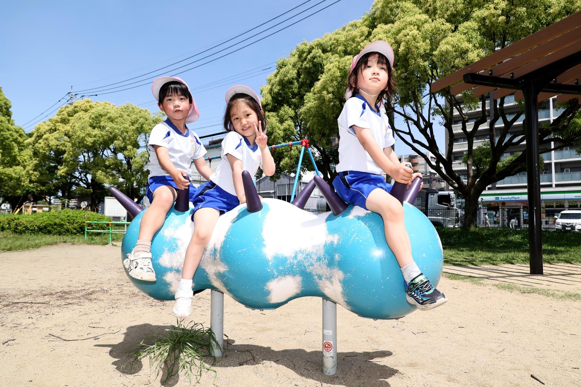 友達3人で、遊具に乗っているところ
