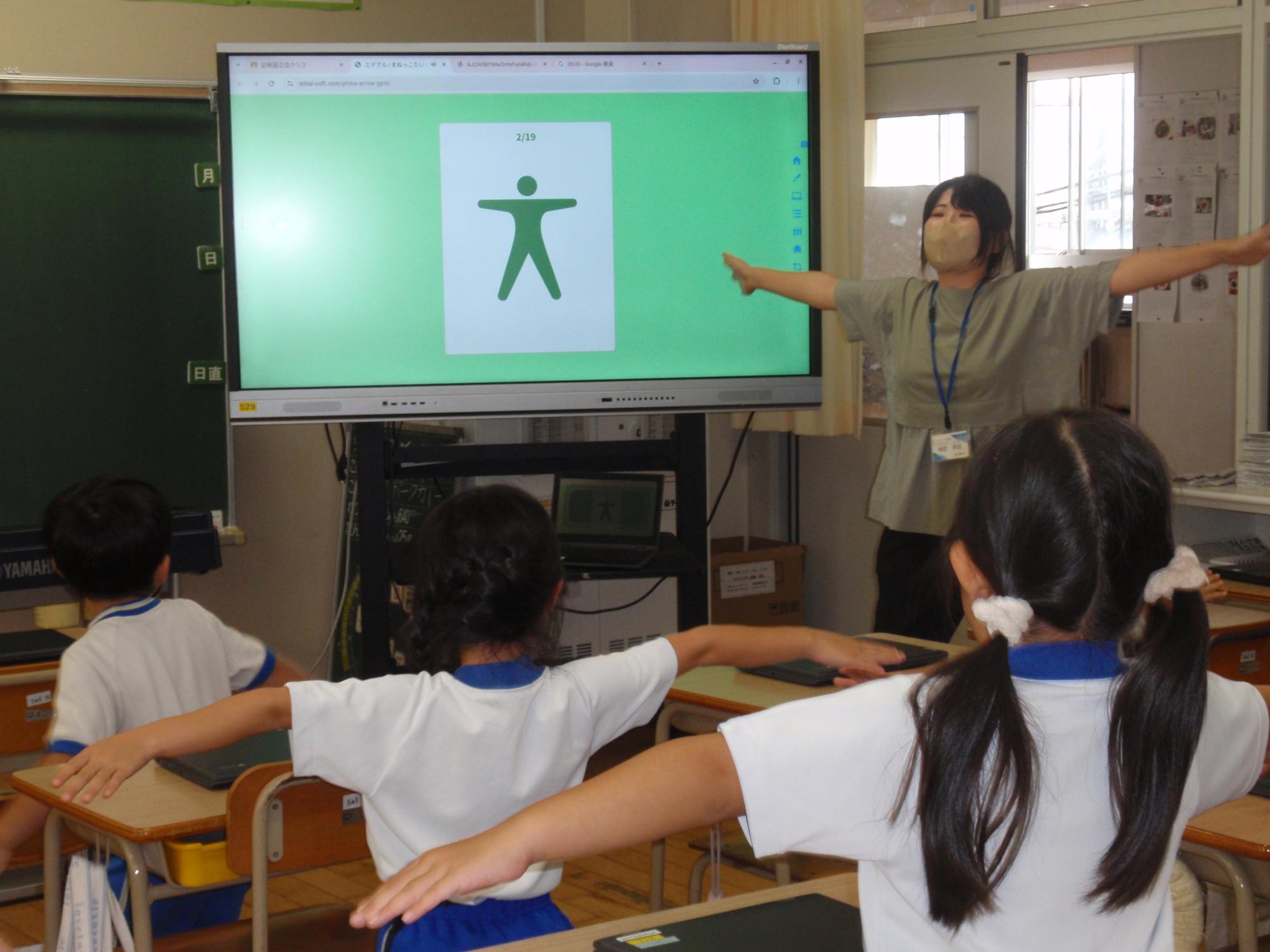 電子黒板に映るピトグラムの動きに合わせてまねっこ遊びをする年長さん