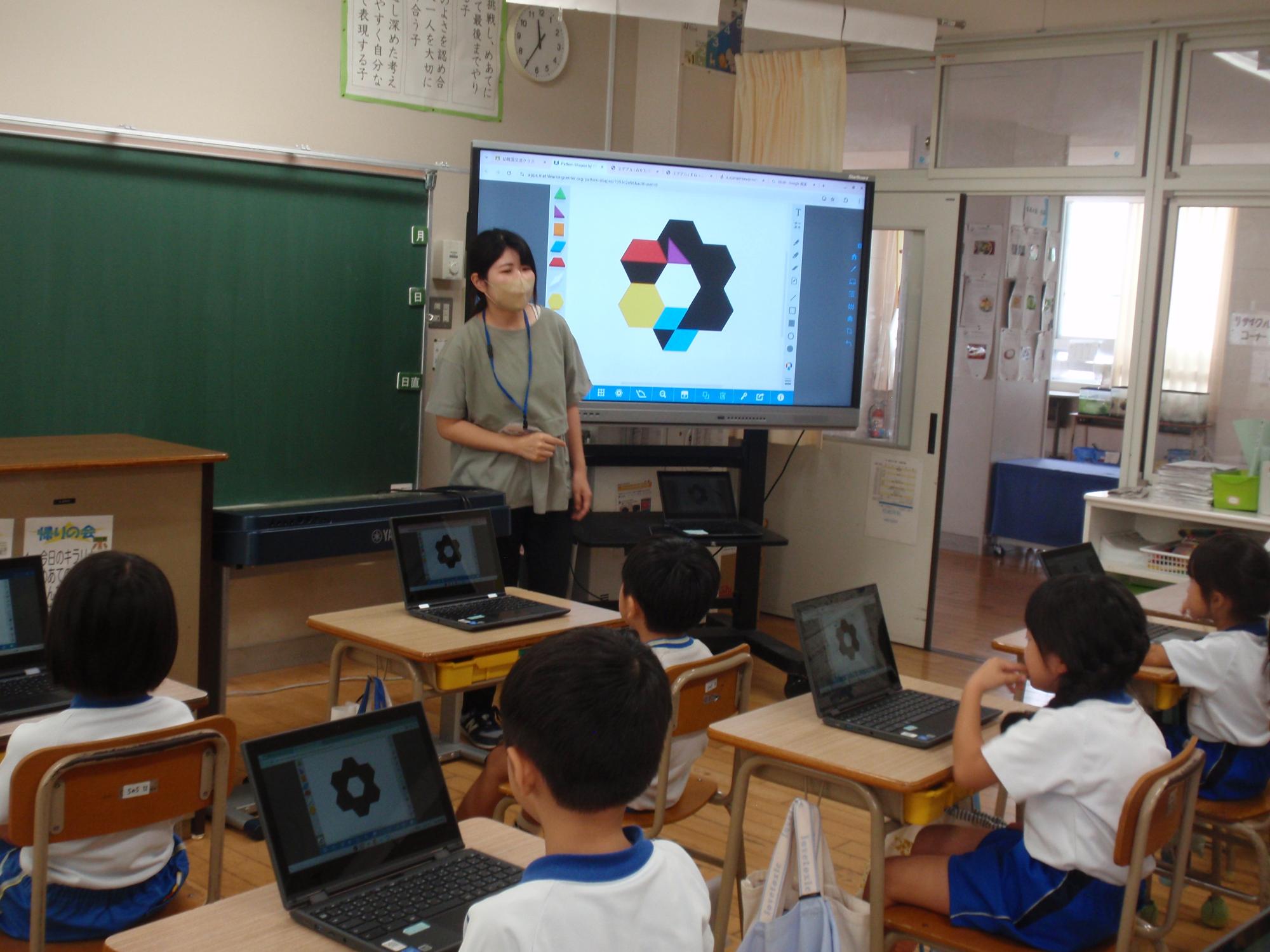 タブレットを使って形合わせのゲームをする年長さん
