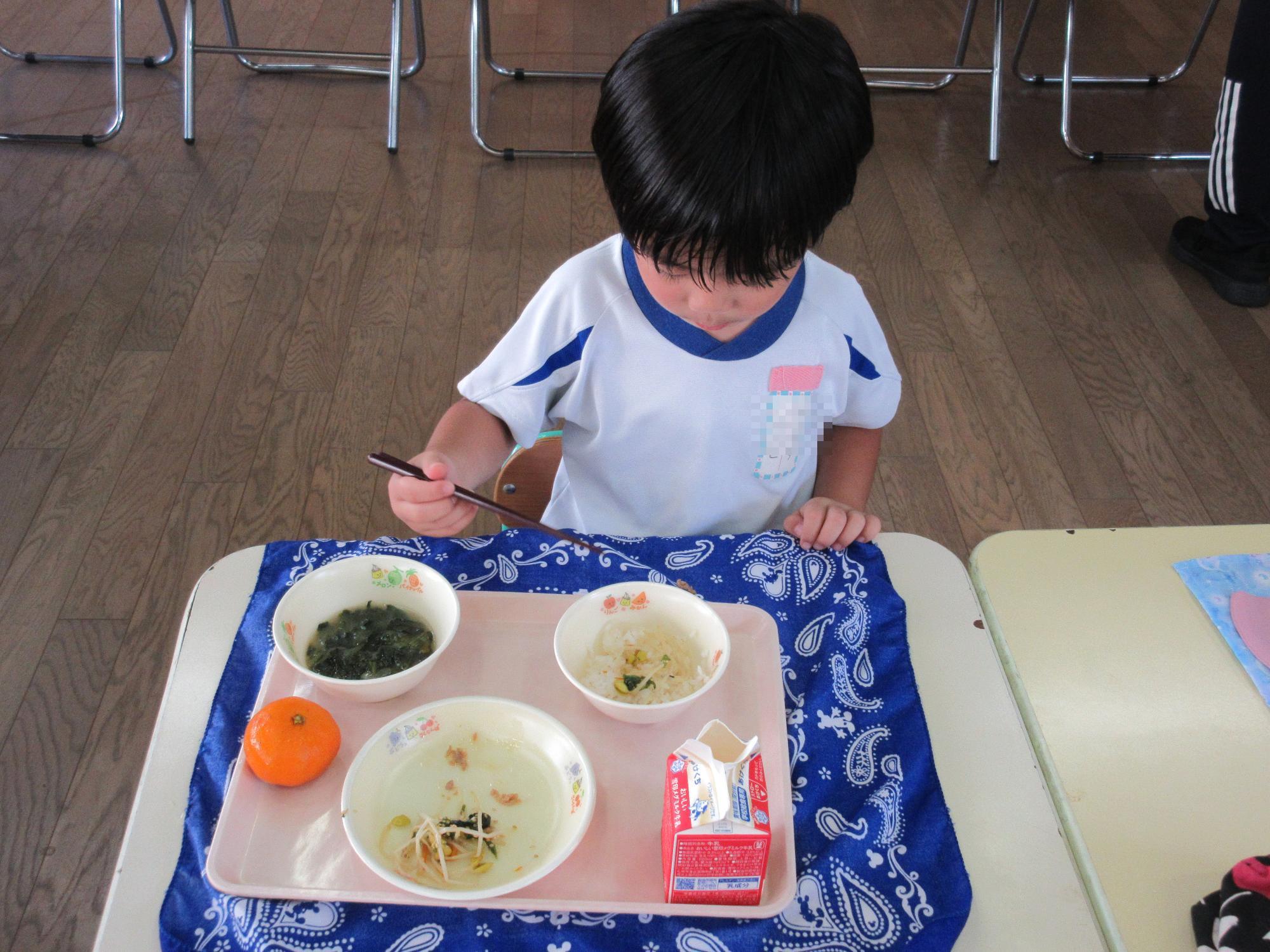 男児が苦手な野菜にも挑戦している様子