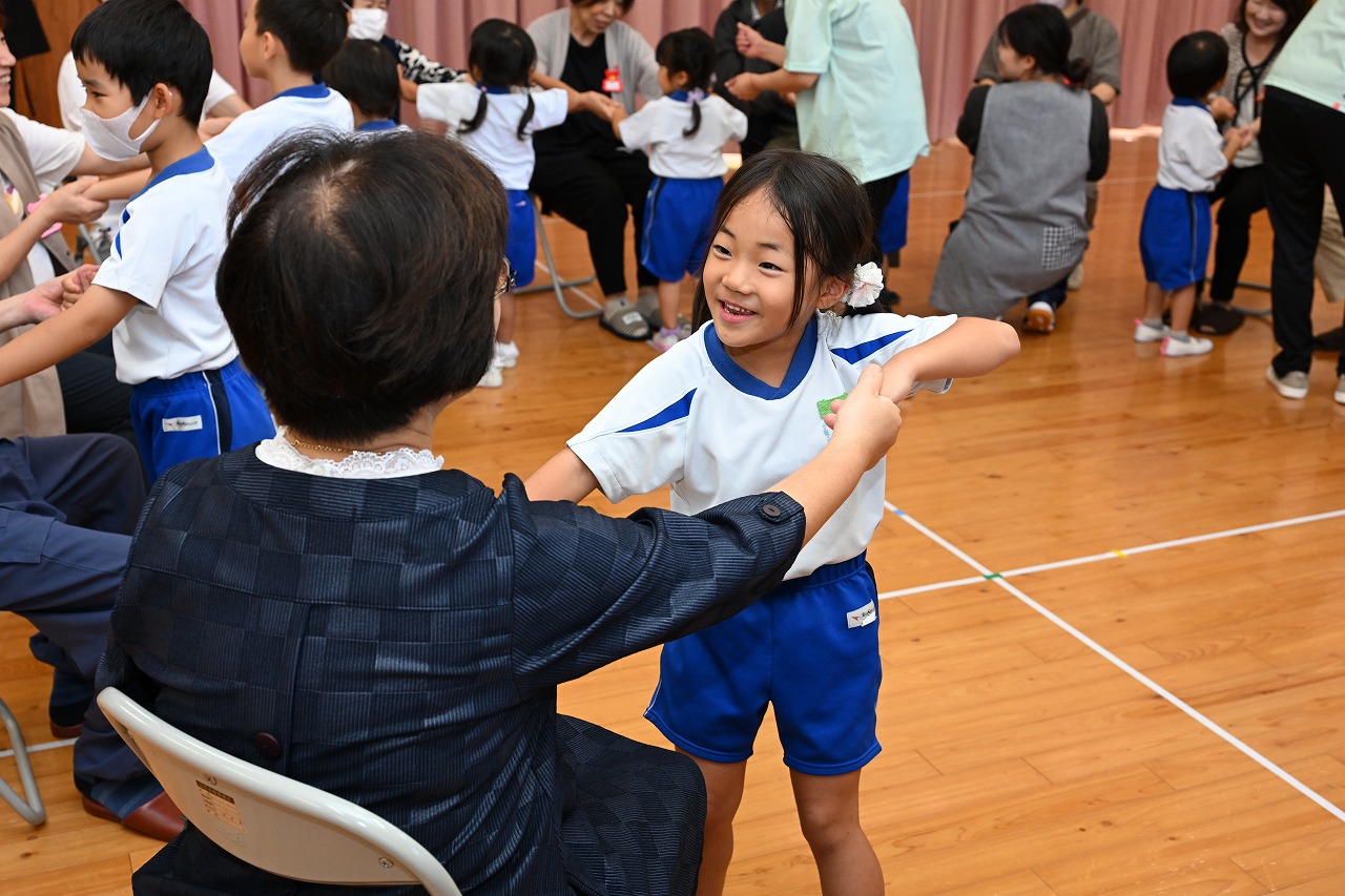 女児がお祖母ちゃんの手をつないでふれあい遊びをしている様子