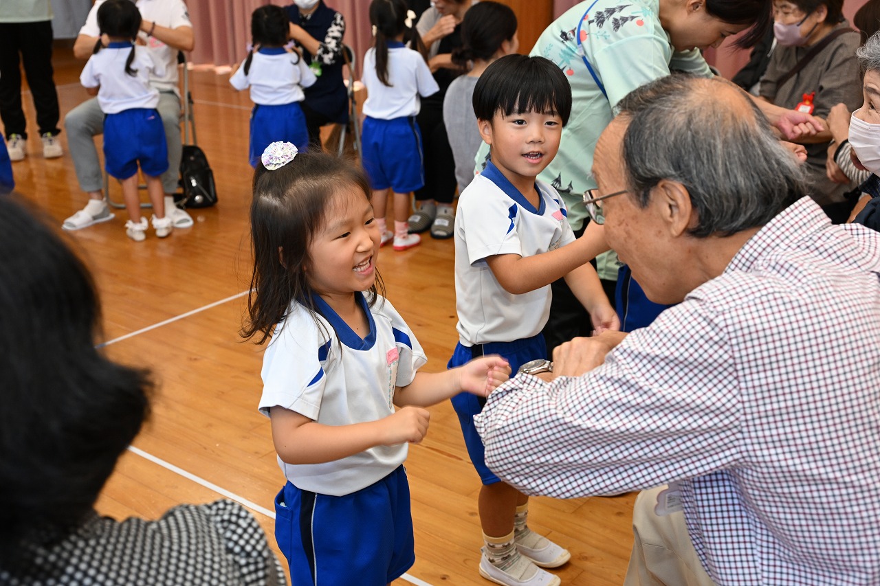 年中女児とおじいちゃんとでふれあい遊びをしている様子