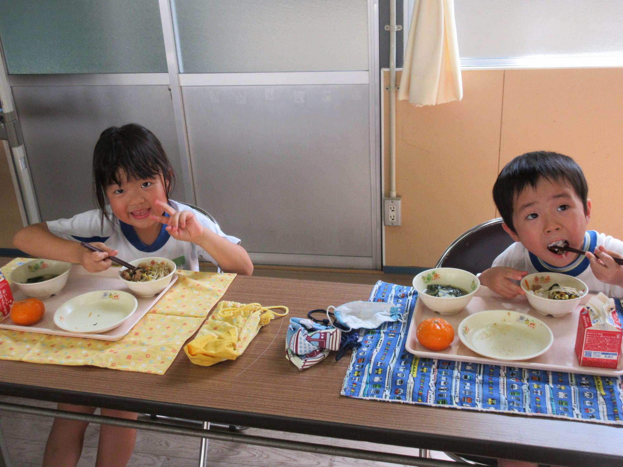 笑顔で給食を食べる年長さん2人のようす