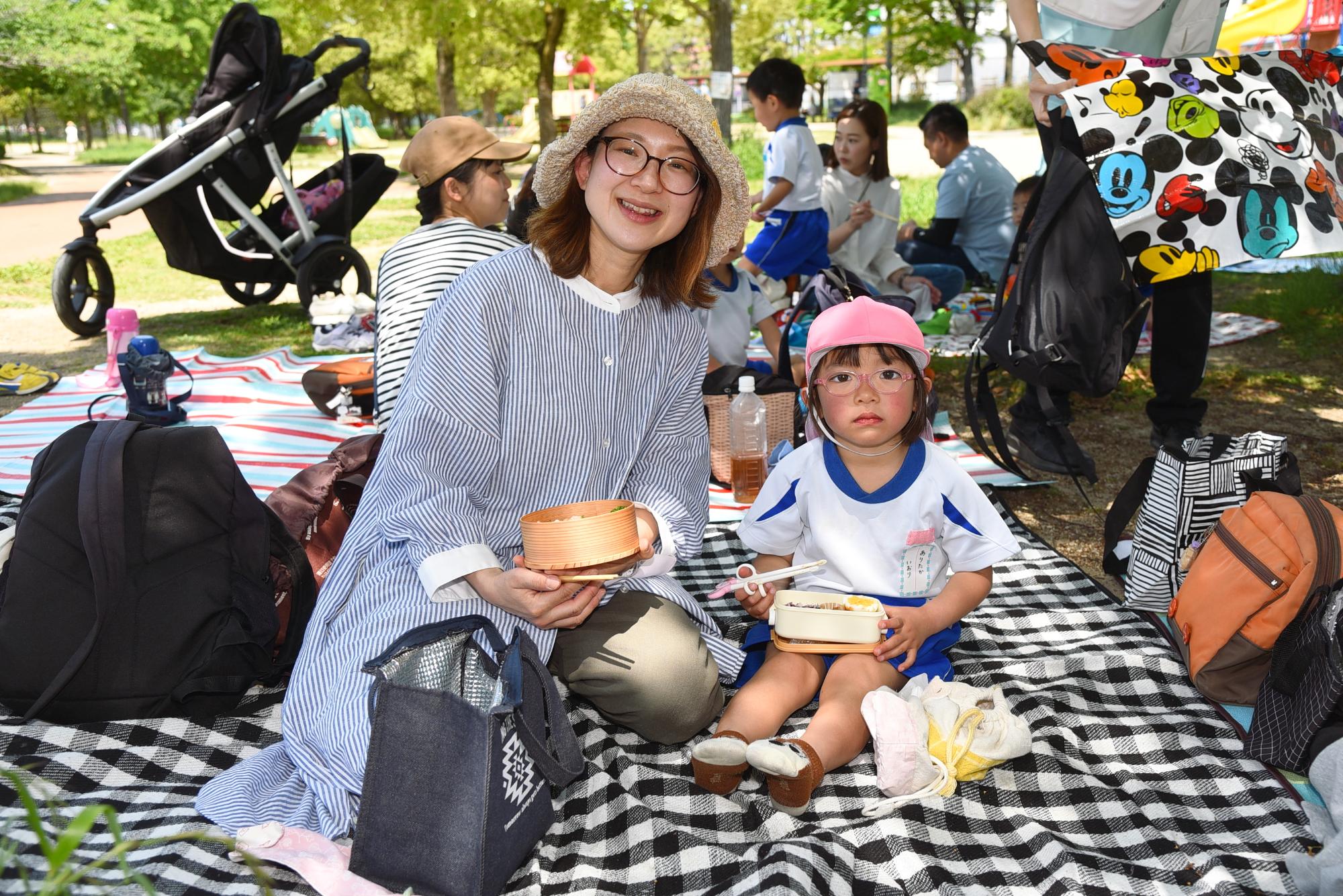親子でそれぞれお弁当を持って、ポーズをとっている様子