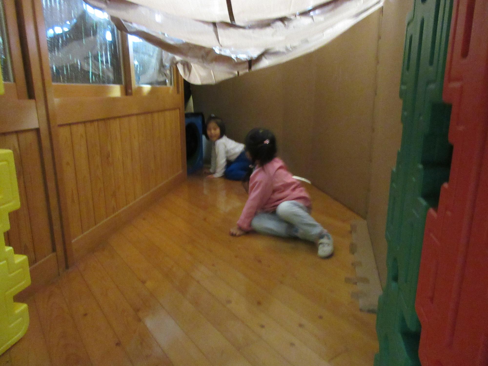 女児2名が四つ這いで、トンネルの中をくぐっている様子