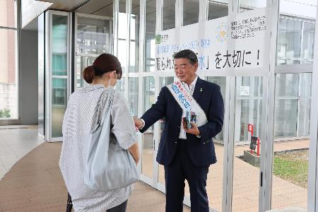 水の大切さを呼びかけながら啓発物品を配布している桐島町長