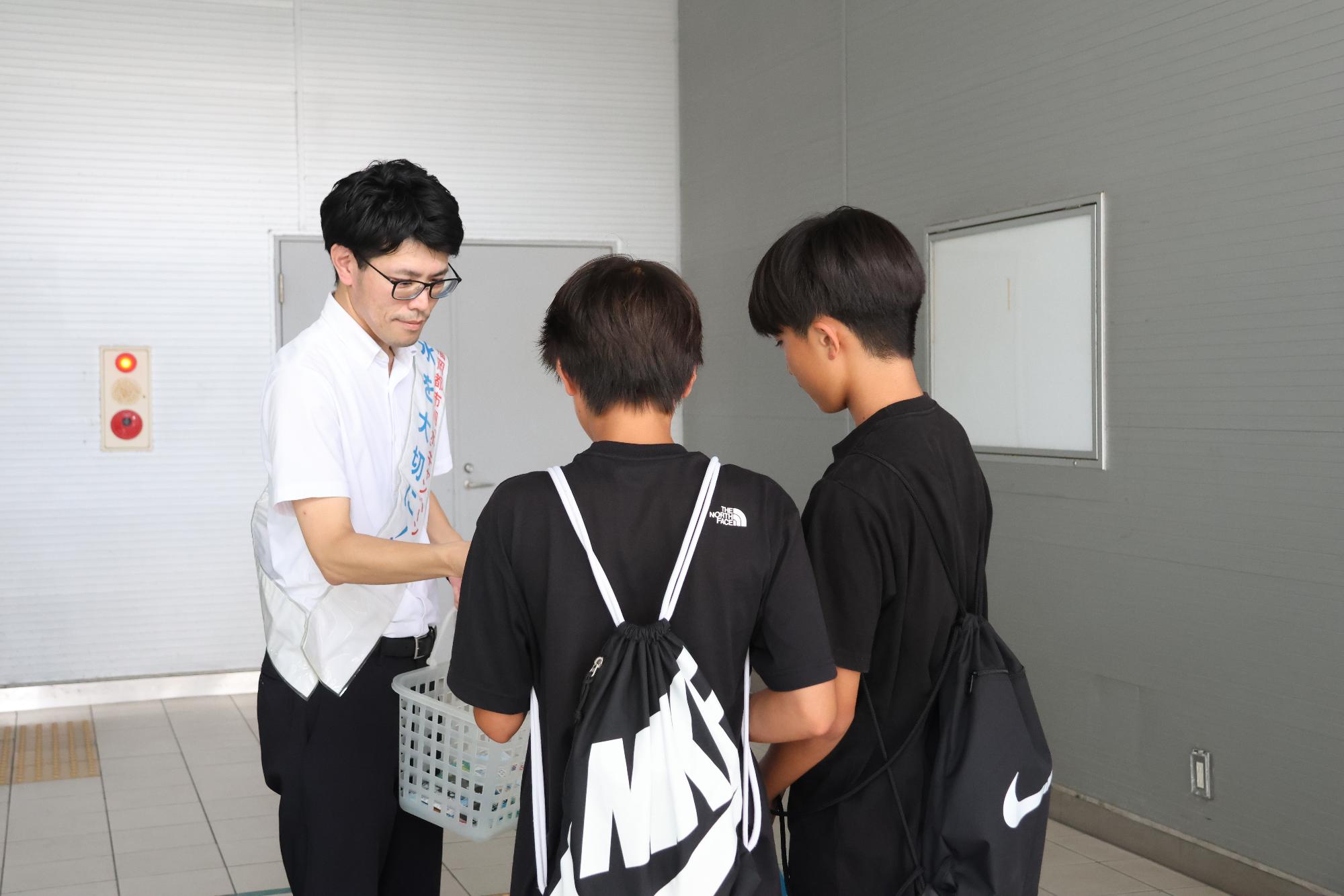 一人ひとりに啓発物品を配布している財間副町長