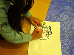 マッキーペンで色塗りをしている女の子の手元を写した写真