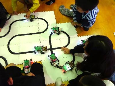 小学生プログラミング教室で車を動かす子どもの様子