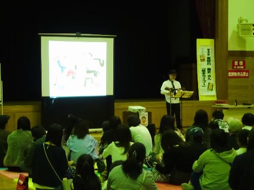 絵本作家・長谷川義史さんがウクレレを弾きながら読みきかせする様子