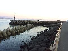 港に石を積んで作られた波止場があり、海まで細長く突き出している写真