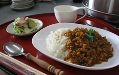トレーにスプーンとお箸、即席漬け、白いカップに入った甘酒ラッシー 、キーマカレーが並べられている写真