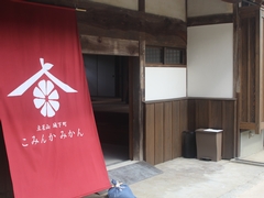 店舗入り口に飾られたこみんかみかんのタペストリーの写真