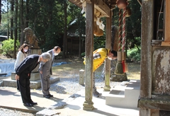 町長や関係者が神社本殿の前に立ち、頭を下げて祈願をしている写真