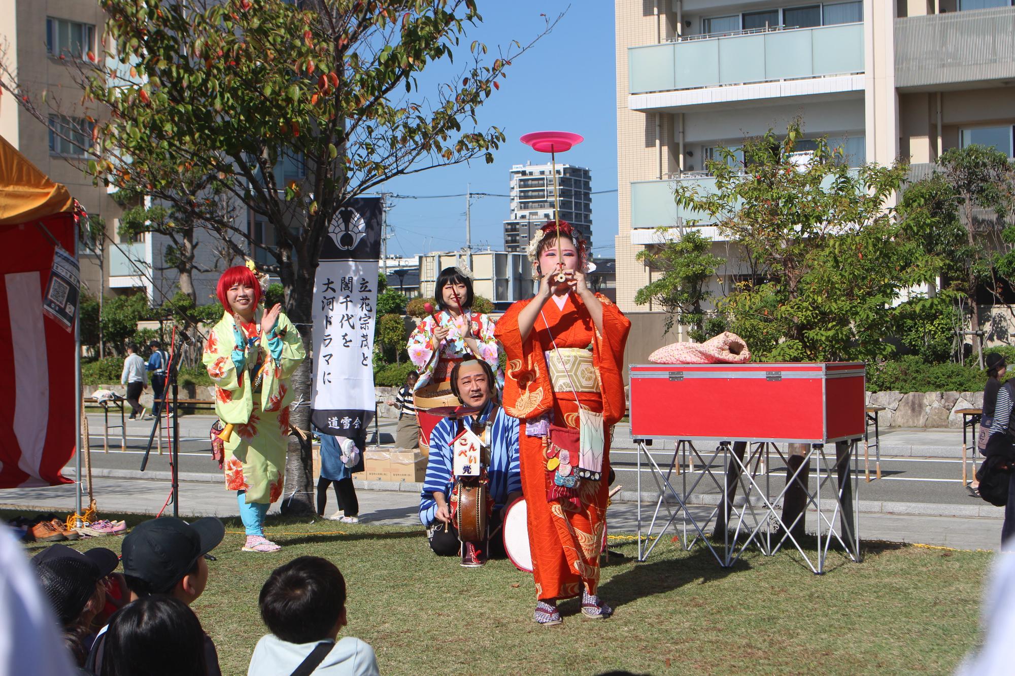 ちんどん屋「こんぺい党」が芸を披露している写真